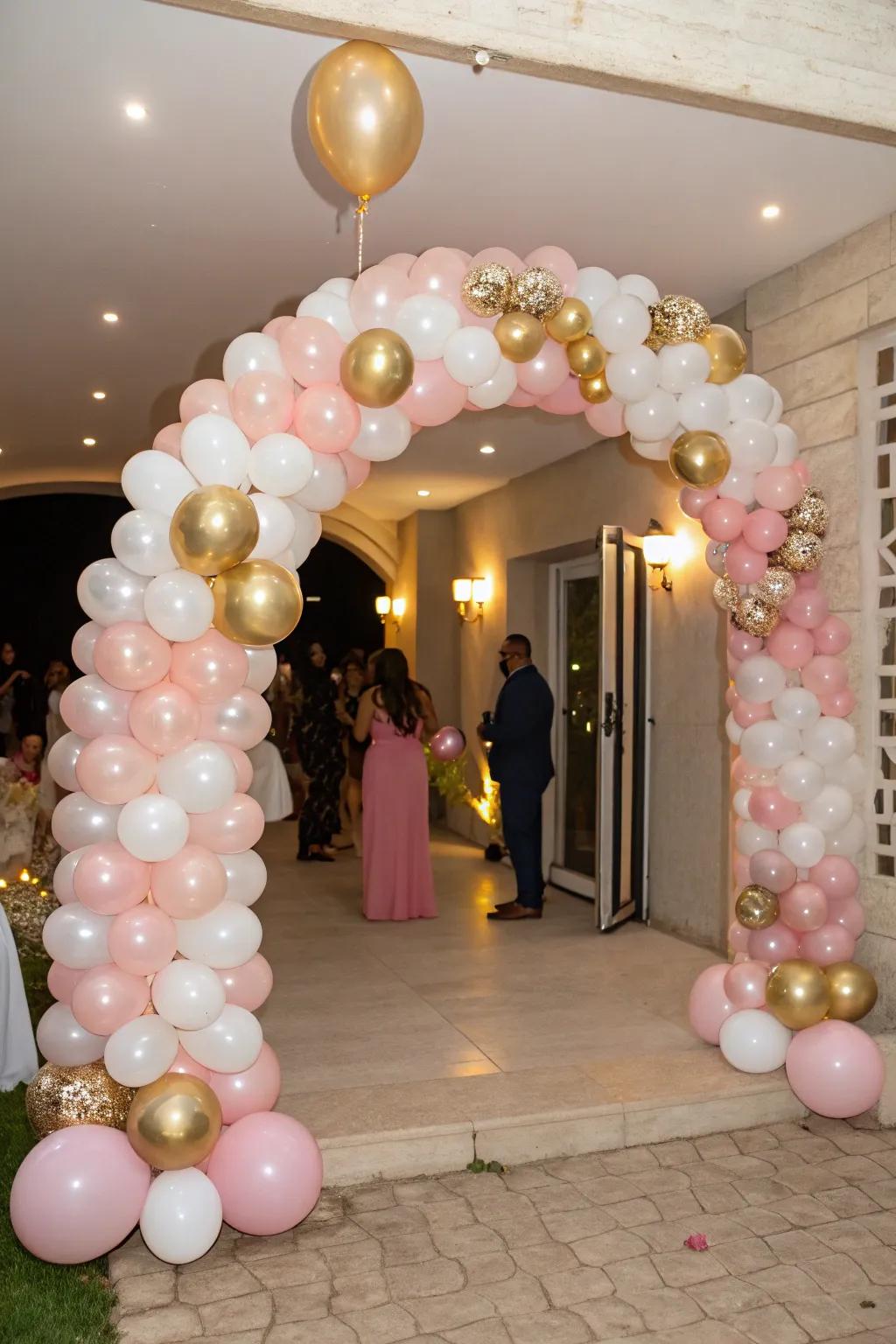 A beautiful balloon arch in pink, gold, and white sets a welcoming tone.
