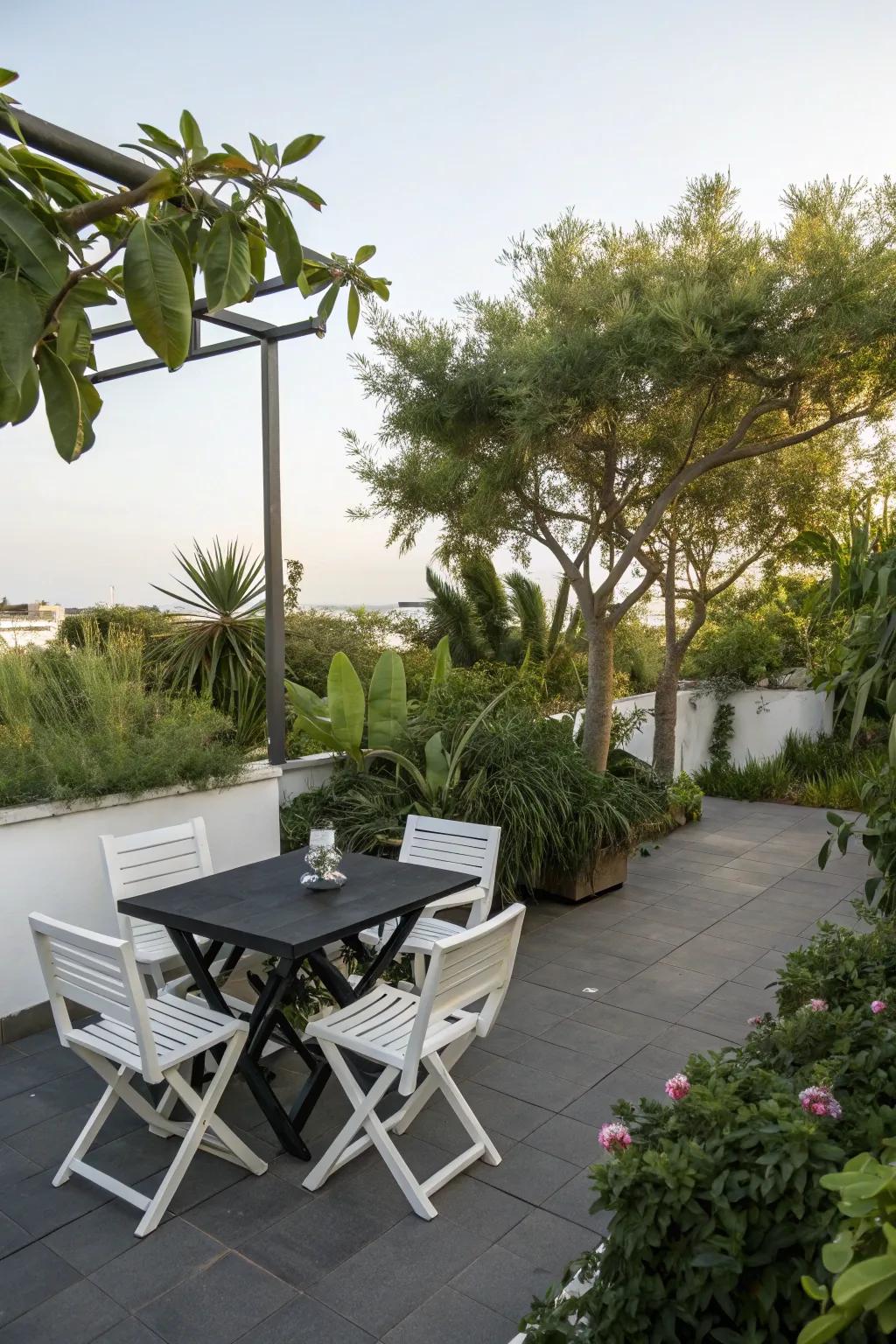 A contemporary patio featuring a black table and white chairs, ideal for a stylish social gathering.