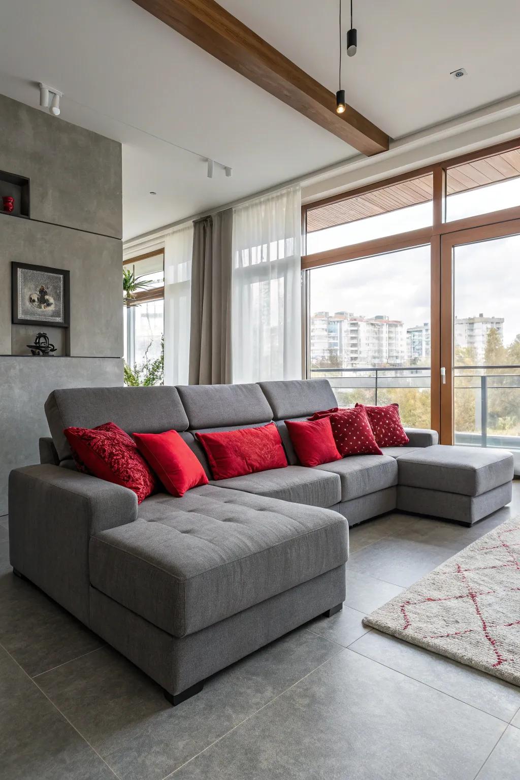 An inviting living space showcased by a grey sectional and crimson pillows.