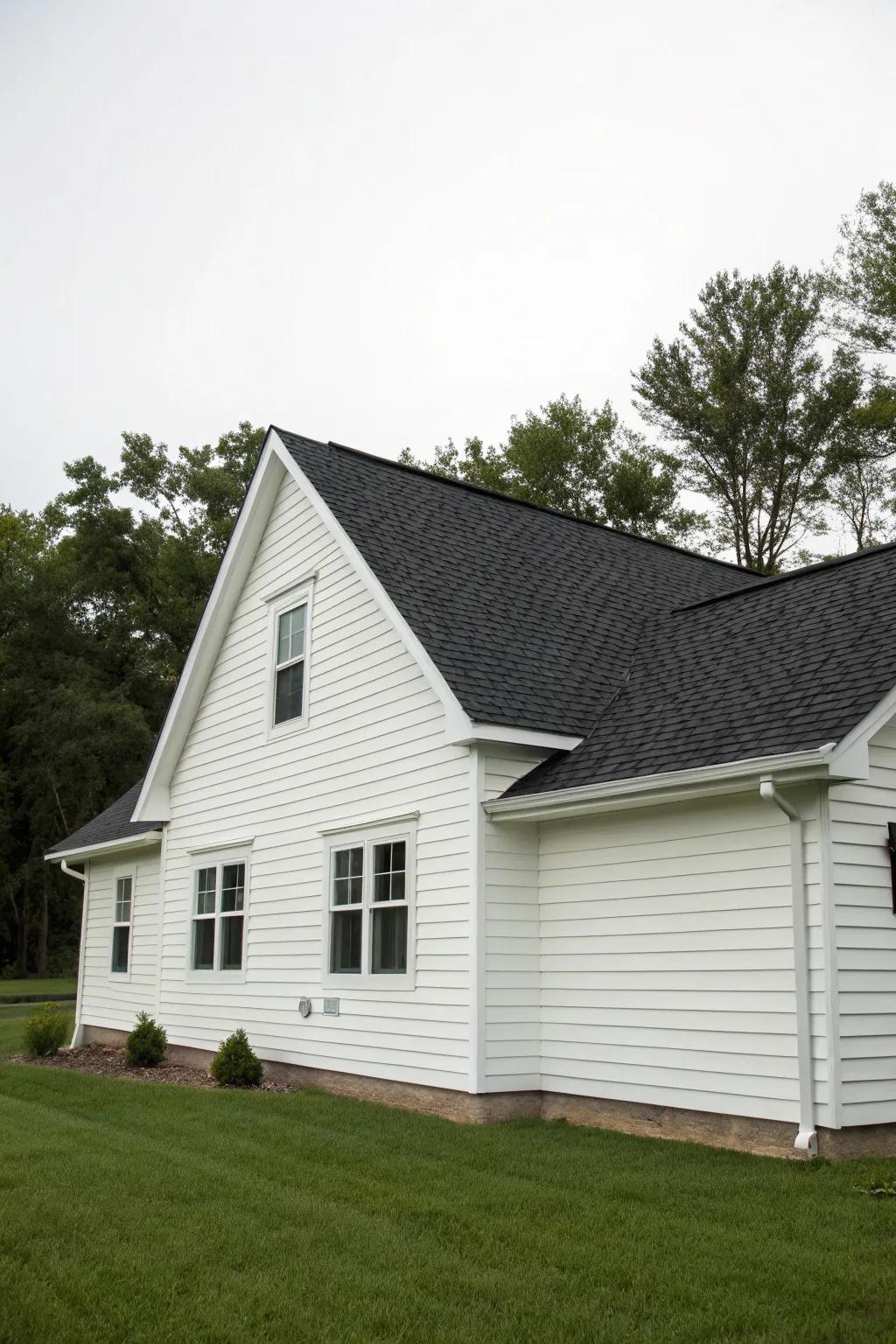 A house with a bold, contrasting dark-toned roof and white vinyl siding.