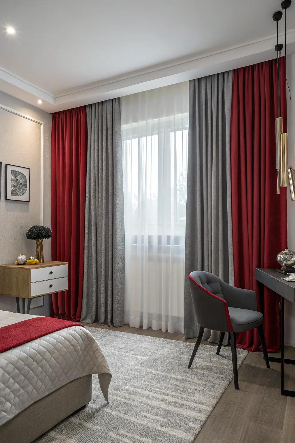 Layered crimson and ash-grey drapes in an intimate bedroom inject elegance and light control.