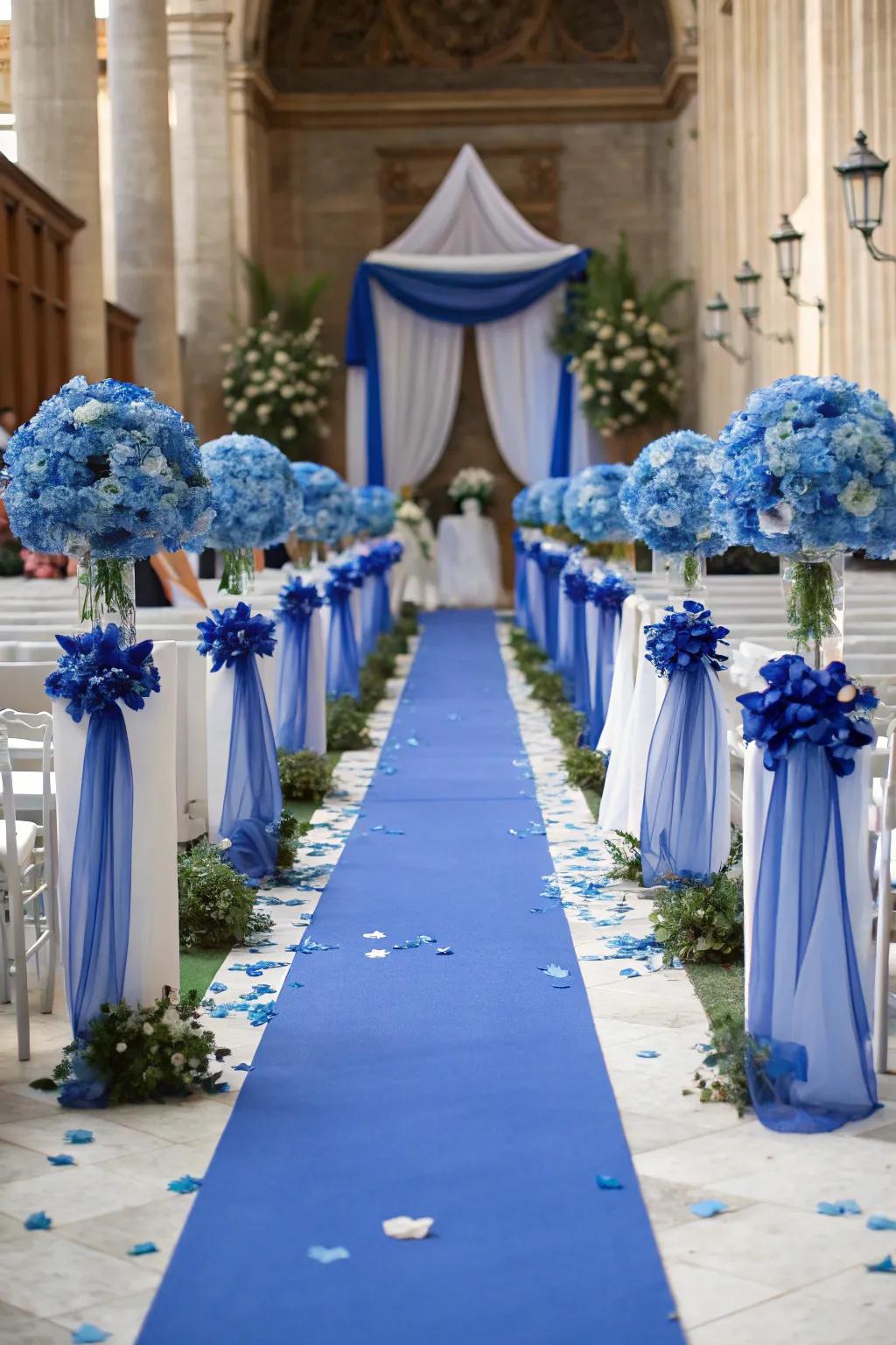 A beautifully decorated ceremony aisle with royal blue accents.