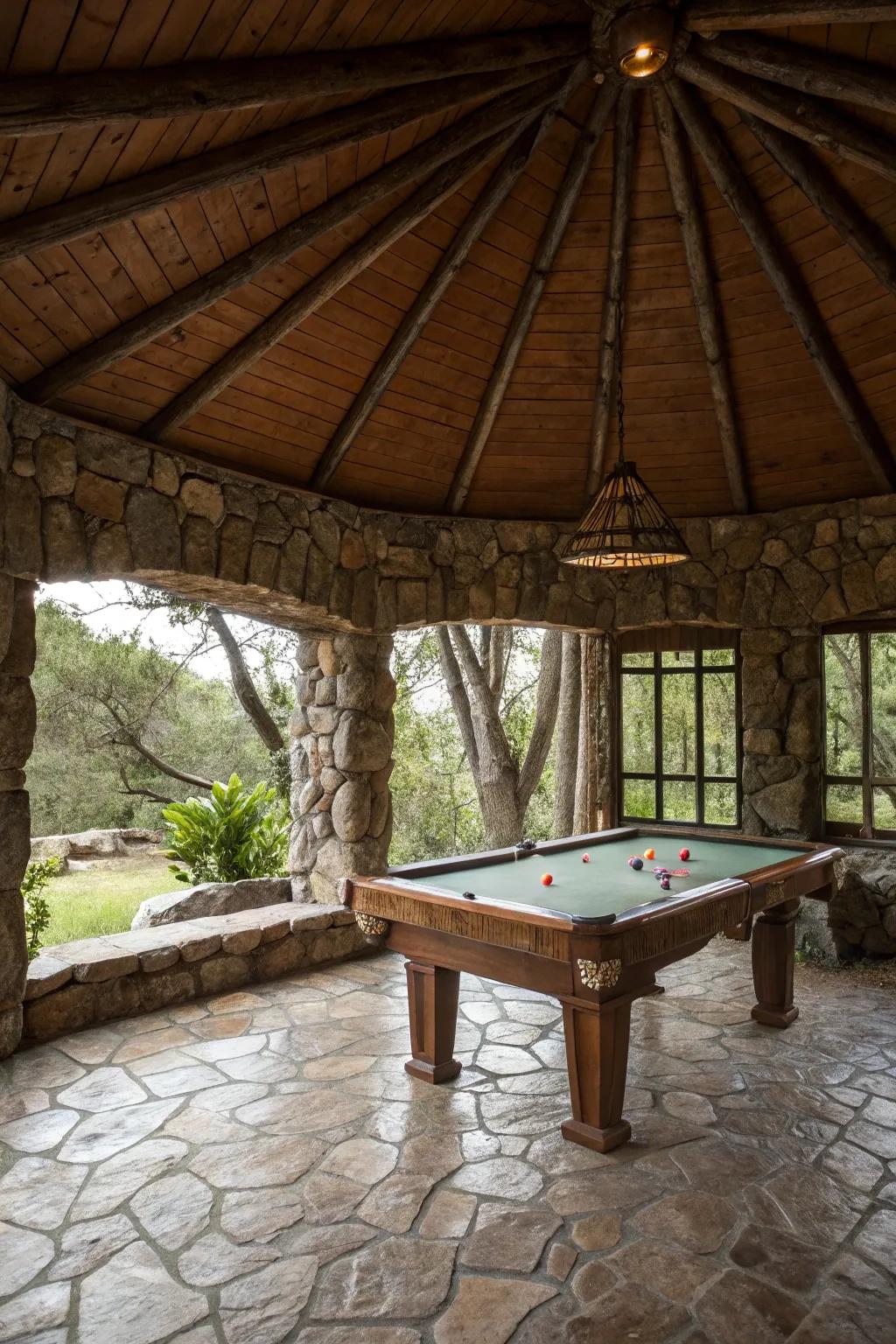 A country stone gazebo housing a snooker table in a natural setting.