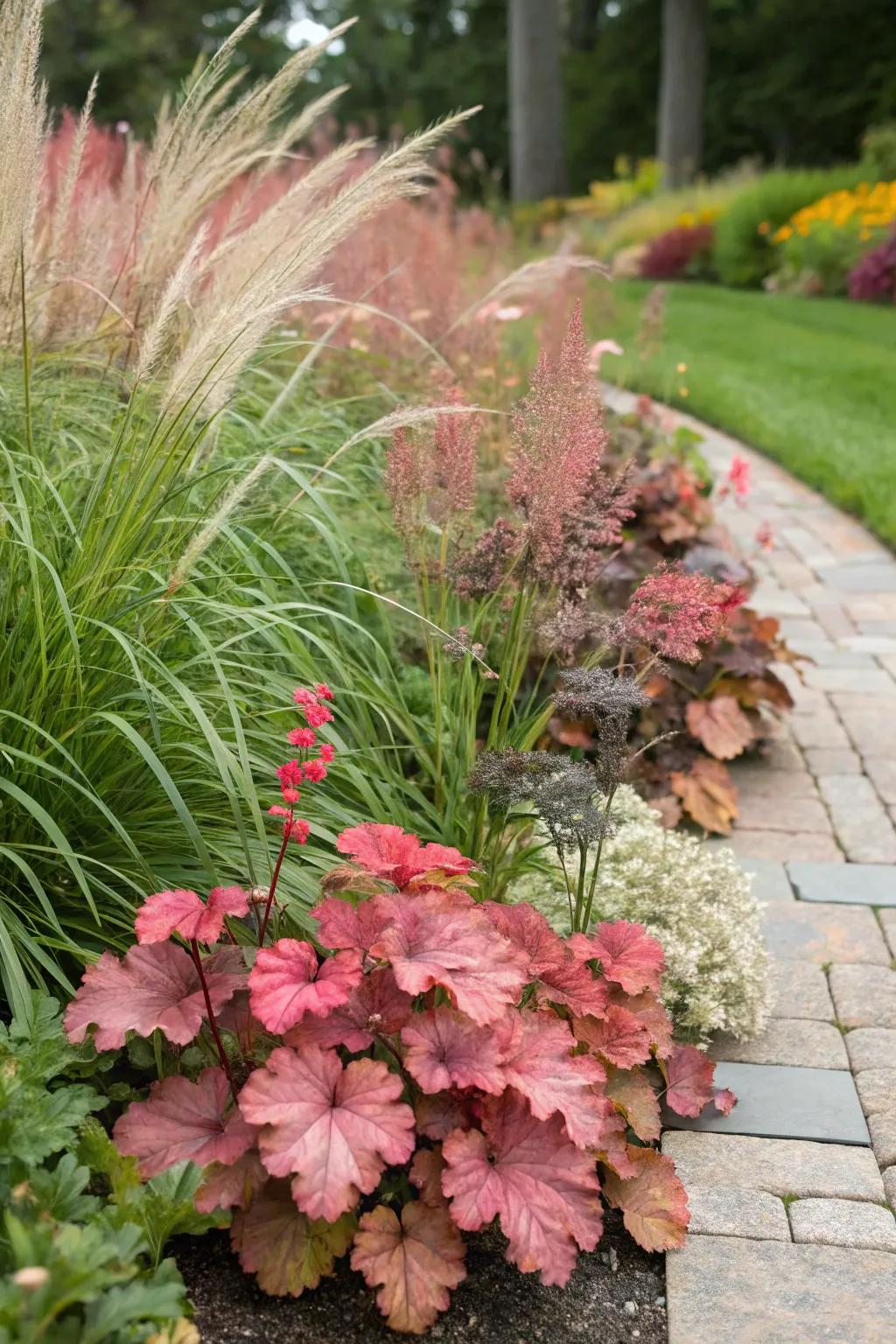 Huecheras intermingled with ornamental grasses craft a lively presentation in the garden.