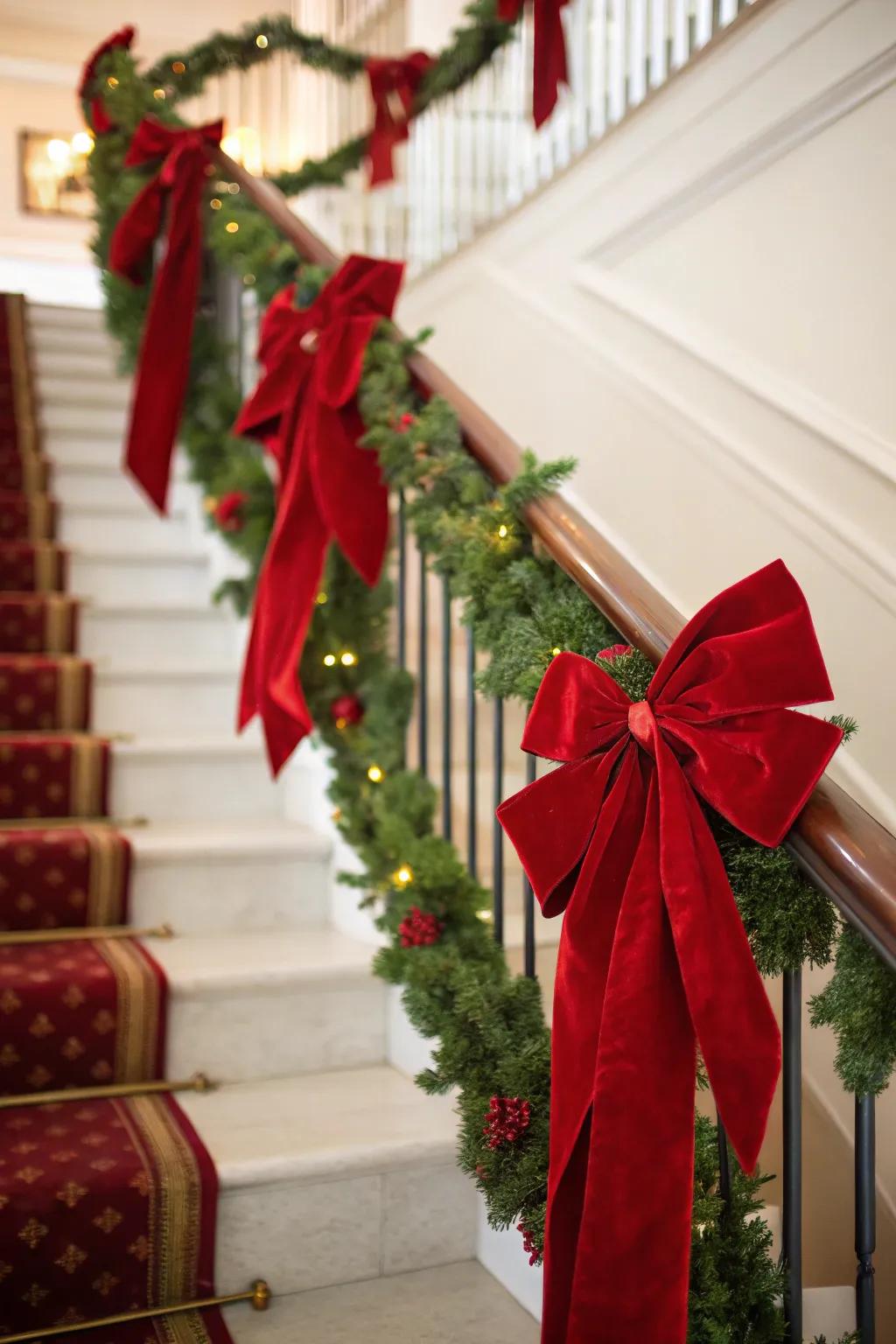 Staircase embellished with crimson velvet bows and ribbons.