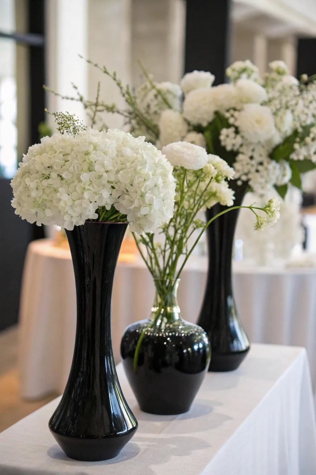 Elegant white flowers combined with black vases.