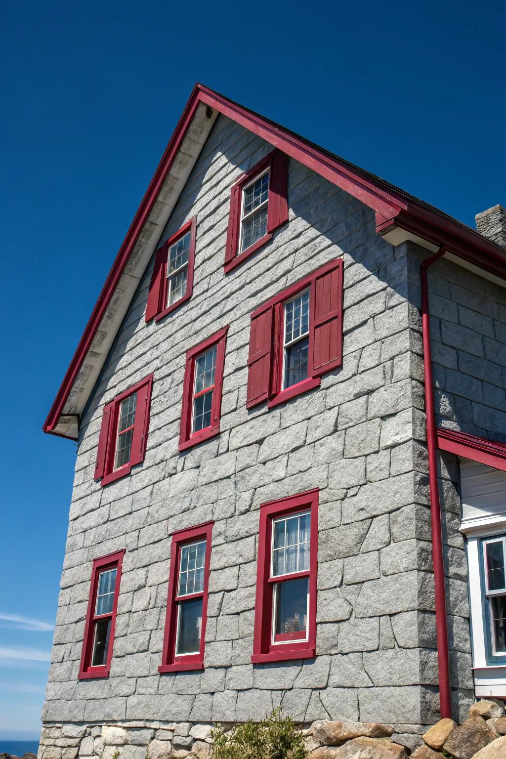 Vibrant crimson trims provide a surprising contrast to this gray stone facade.