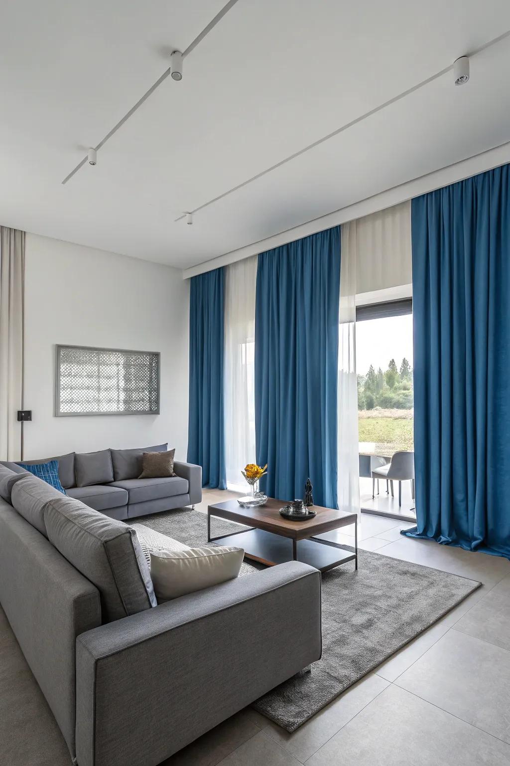 Blue curtains and gray furniture create a contemporary, harmonious living space with a balanced color scheme.