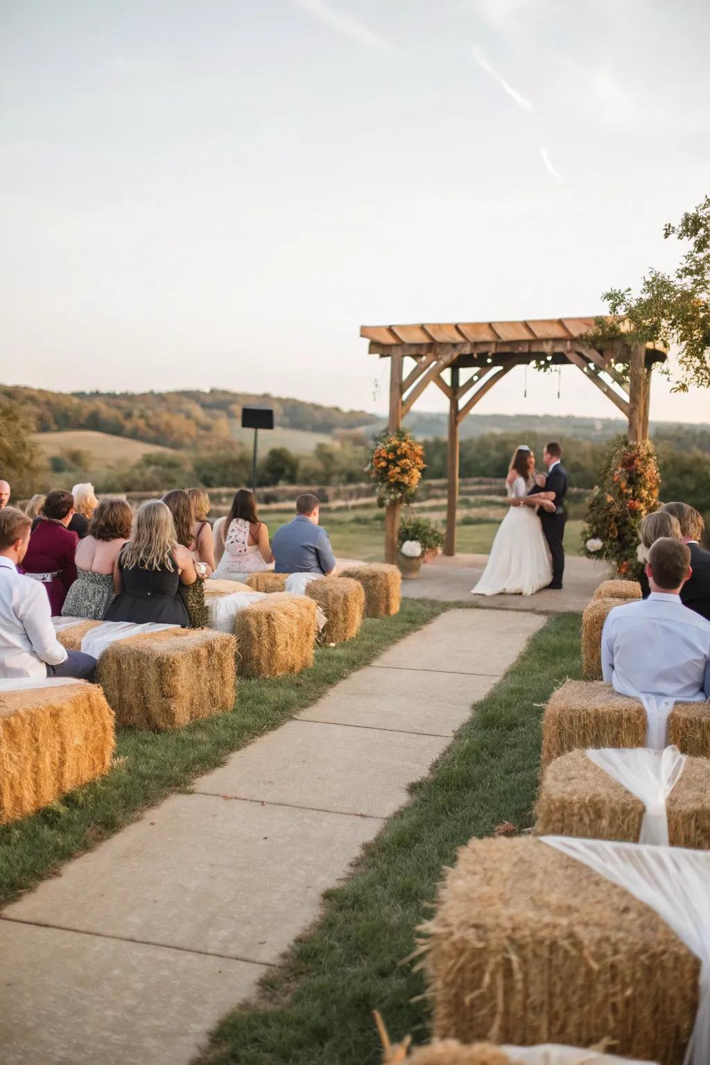 An unpolished wedding ceremony with hay bundle seating covered in comfortable material.